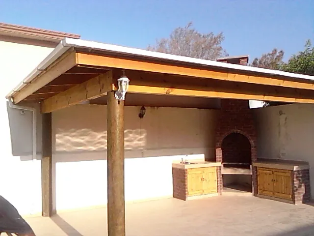 Asador de ladrillo, puertas de madera y techo un agua con piso ceramico